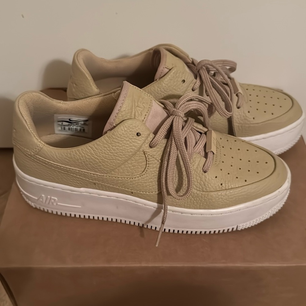 Nike Air Force 1s, tan leather with a white sole.